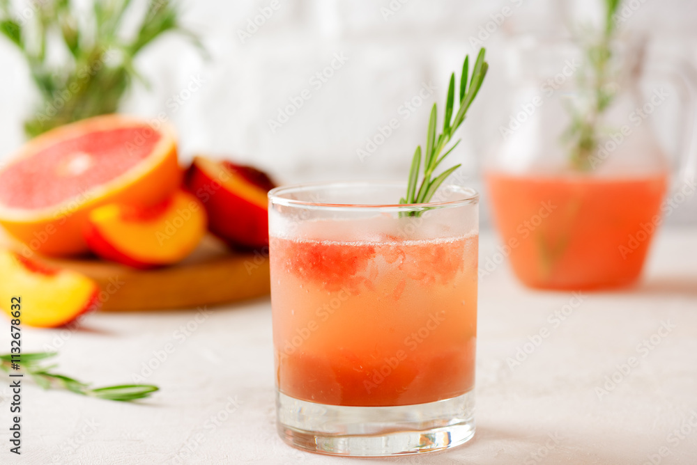 Fototapeta premium Grapefruit and peach drink, tea, lemonade, cocktail with rosemary. Healthy drink, sugar and alcohol free.