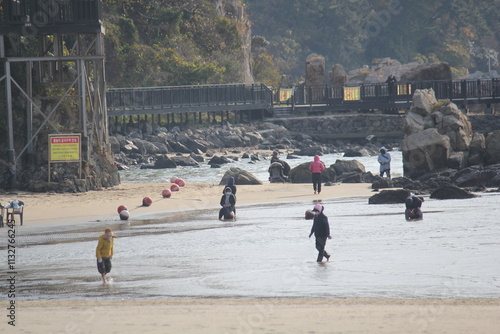 Image of people walking barefoot at Dadaepo Beach in Busan
 photo