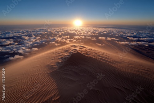 A breathtaking view of sun rising over majestic sand dunes, casting shadows and creating a golden glow across the desert landscape. A tranquil and awe-inspiring moment captured. photo