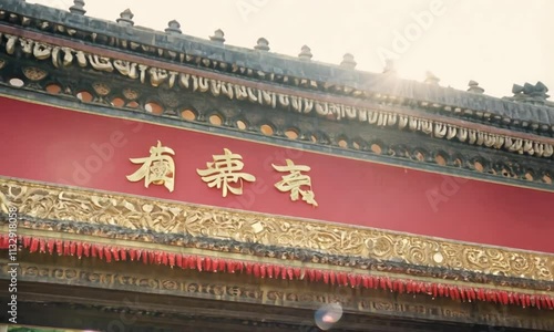 Chinese architecture featuring vibrant red banners with golden inscriptions for New Year celebrations. photo