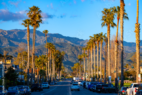 Carpinteria is a small town on the Pacific coast of California. The bustling main street of the resort is lined with tall palm trees. Panoramic shot on a sunny spring day in warm evening light.