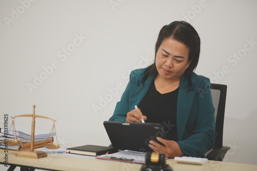 Pretty Asian female lawyer working and hammer, laptop, justice advice and legal concept. In office photo