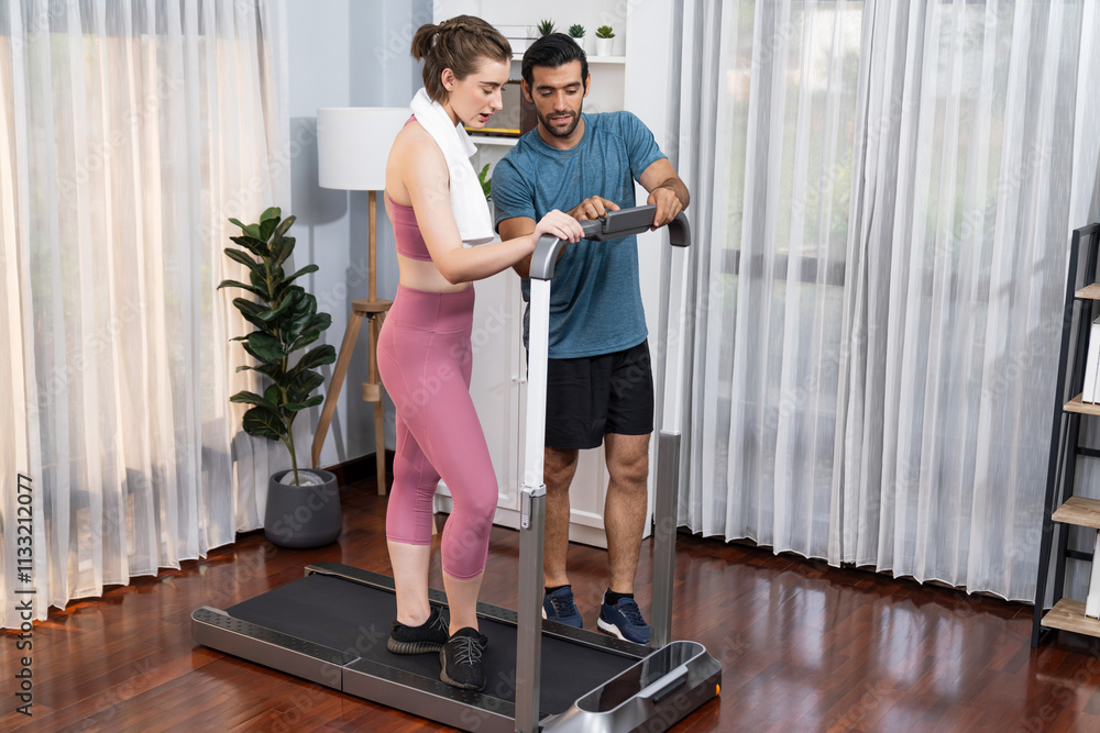 Fototapeta premium Athletic and sporty young couple or fitness buddy running on running machine together, home body workout exercise session as healthy sport lifestyle at home. Gaiety home exercise workout training.
