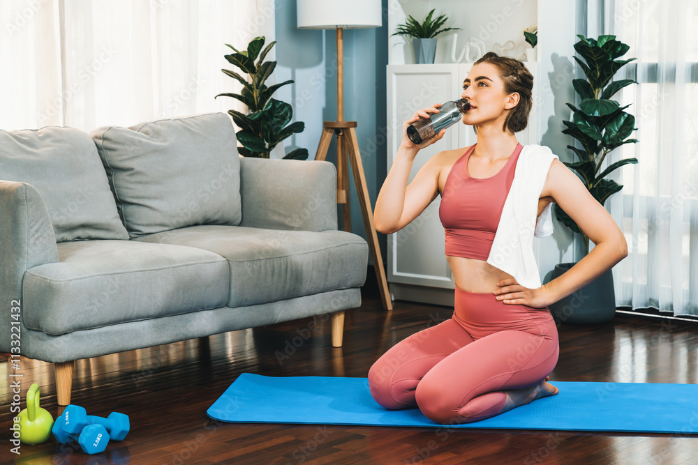 Obraz premium Athletic and sporty woman drinking water on fitness mat after finishing home body workout exercise session for fit physique and healthy sport lifestyle at home. Gaiety home exercise workout training.