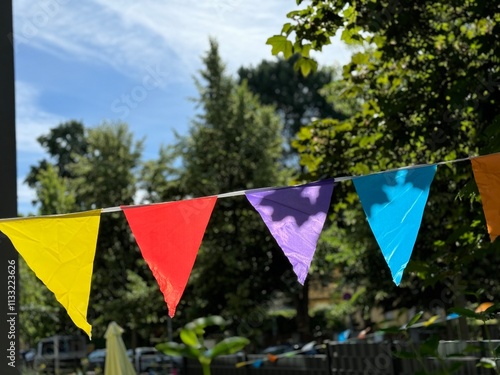 Colorful pennant Summer party string decoration against a tree and the summer sky