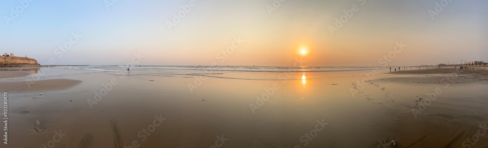 Fototapeta premium Orange light of sunset on beach in Karachi looking very nice.