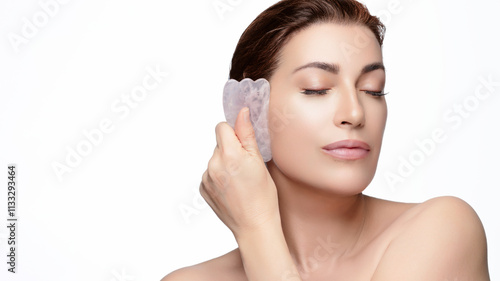 Natural beauty woman using gua sha for skincare routine and relaxation photo