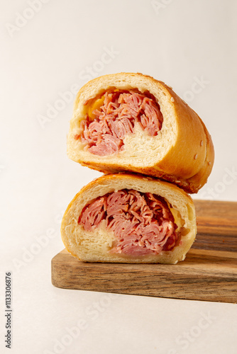 Cachito of ham. bread of ham, over a wooden plate on white background