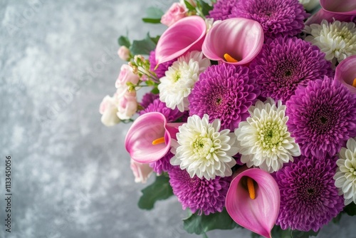 Colorful floral arrangement featuring purple and white blooms on a gray backg...
