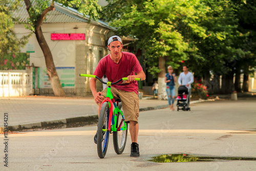 Young man on sport bike. Outdoor fitness. Biking. Bright slopestyle dirt jump bike. MTB photo