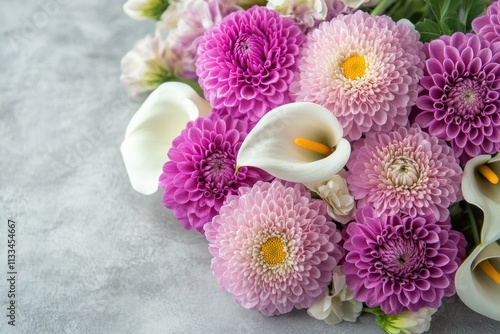 Colorful floral arrangement featuring purple and white blooms on a gray backg...