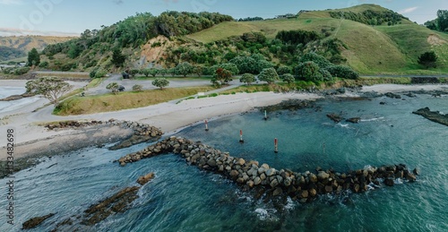 Coastal rock groyne, calm waters, scenic view. Marking buoys in place. KUAOTUNU BOAT RAMP, KUAOTUNU, COROMANDEL PENINSULA, NEW ZEALAND photo