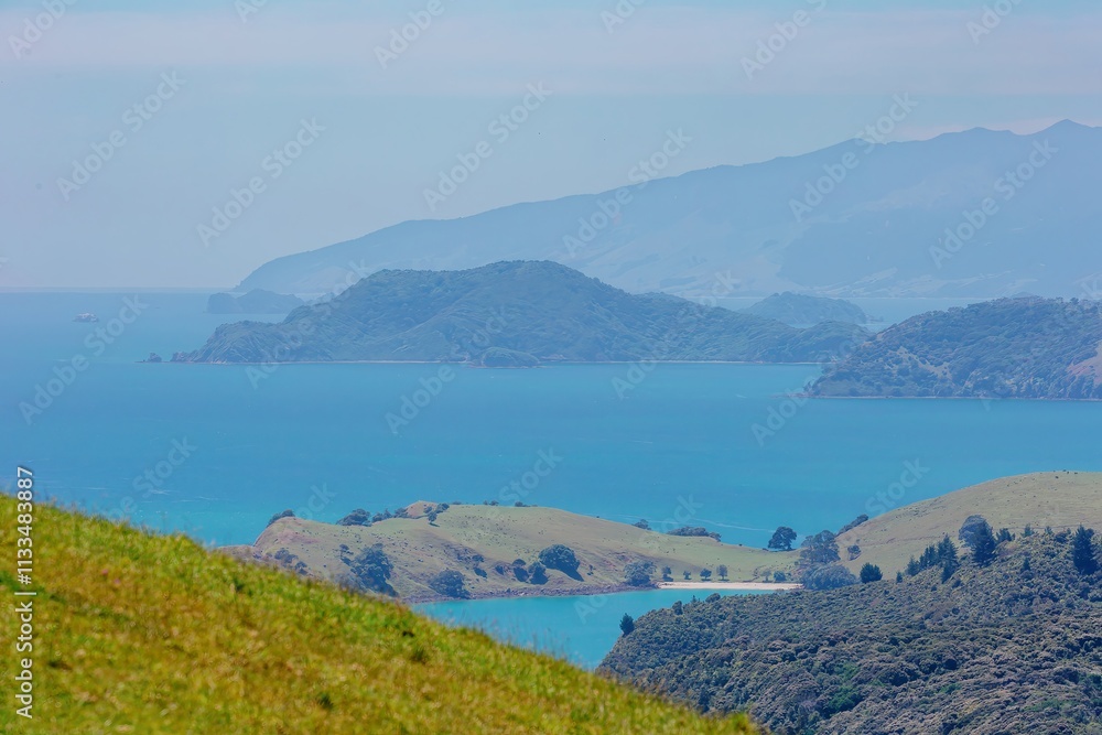 Panoramic view of a tranquil bay, surrounded by lush hills and islands. Coastal scenery. MANAIA, COROMANDEL TOWN, COROMANDEL PENINSULA, NEW ZEALAND Panoramic view of a tranquil bay, surrounded by lush hills and islands. Coastal scenery. MANAIA, COROMANDEL TOWN, COROMANDEL PENINSULA, NEW ZEALAND