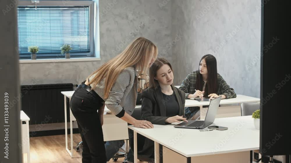 A teacher, walking around the office with all the glass walls, takes a closer look at her students as they're taking the test. A teacher, walking around the office with all the glass walls, takes a closer look at her students as they're taking the test.