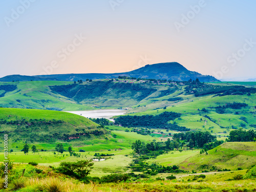 Obraz na płótnie Scenic and tranquil landscape of Drakensberg valley, the dam, and a village on the mountain edge during sunset, KwaZulu-Natal, South Africa w salonie
