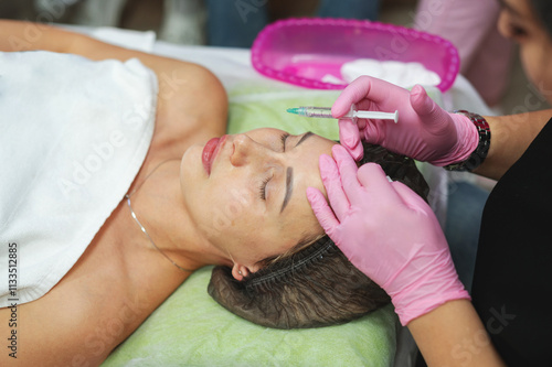 The master cosmetologist shows cosmetology students the technique of how to do biovelitarization in the face. Cosmetology. Youth. Beauty photo