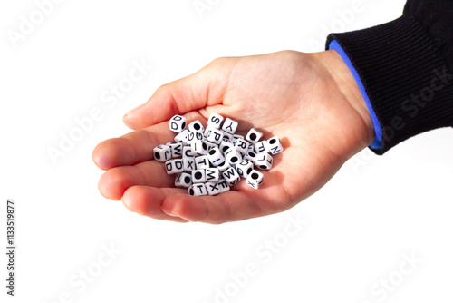 Child holding small dice with letters photo