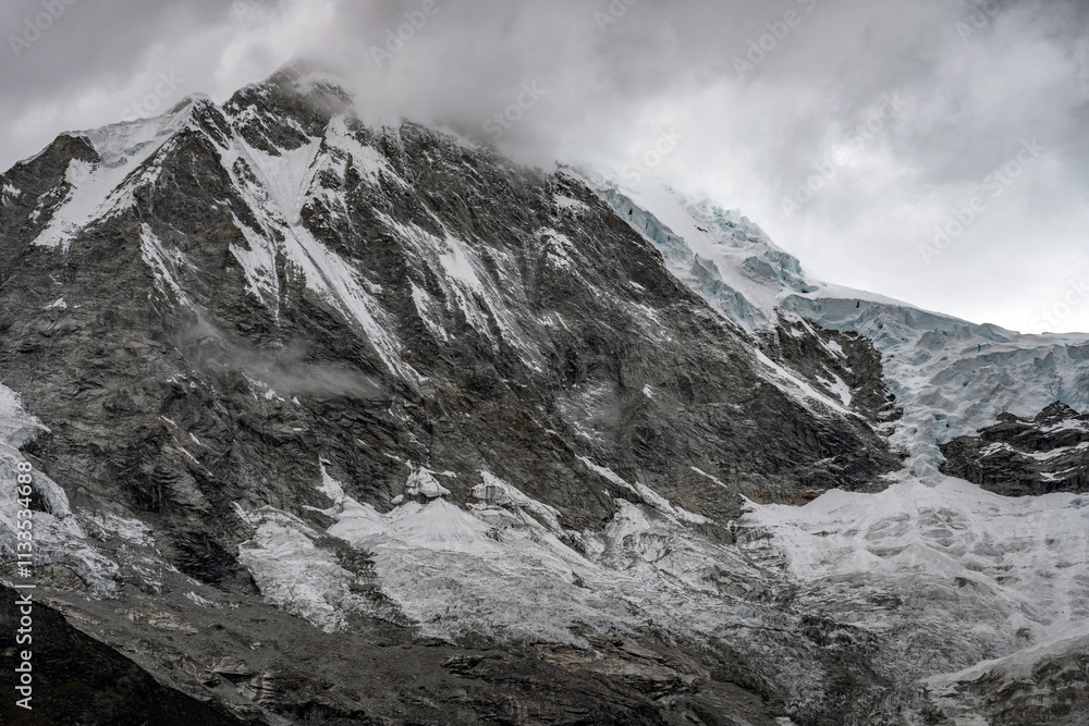 Obraz premium Breathtaking winter landscape featuring snow-covered mountains under a beautiful misty sky.