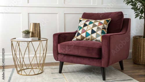 A cozy living room is highlighted by a deepcolored velvet armchair topped with an eyecatching geometric cushion alongside a contemporary brass side table that elevates the photo