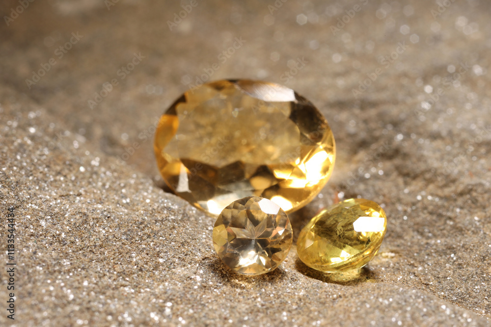 Beautiful shiny gemstones on sand, closeup view Beautiful shiny gemstones on sand, closeup view
