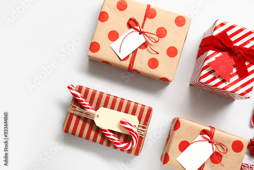 Composition with Christmas gift boxes and candy cane on white background