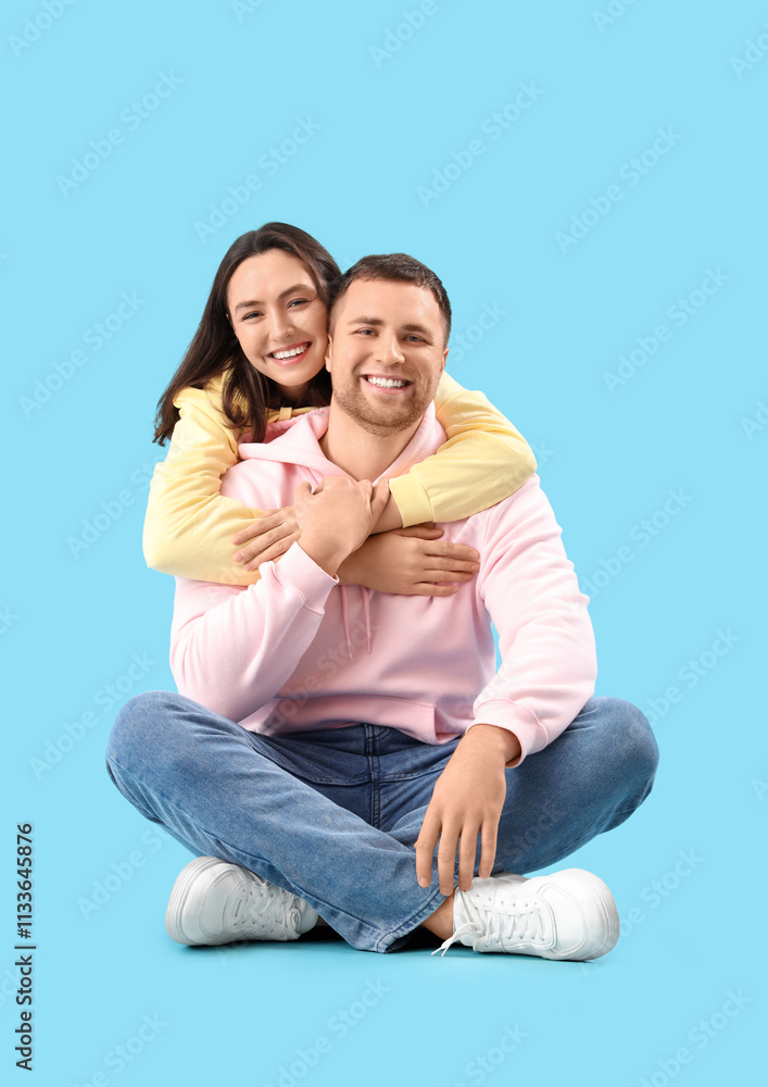 Happy young couple hugging on blue background Happy young couple hugging on blue background