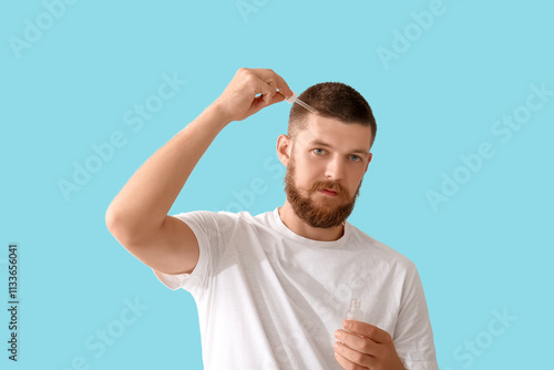 Young man using serum for h...