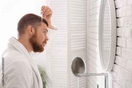 Young man using serum for h...