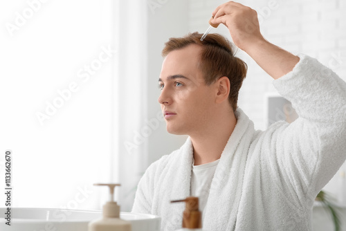 Young redhead man applying ...