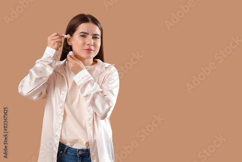 Young woman with otitis usi...