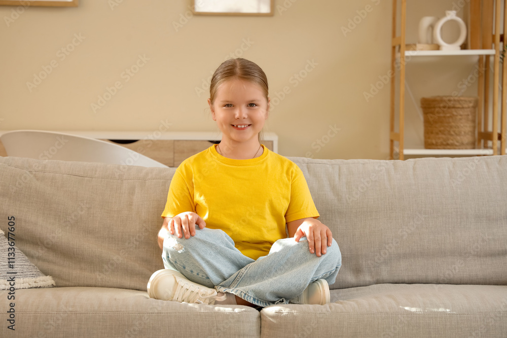 Funny little girl sitting on sofa Funny little girl sitting on sofa
