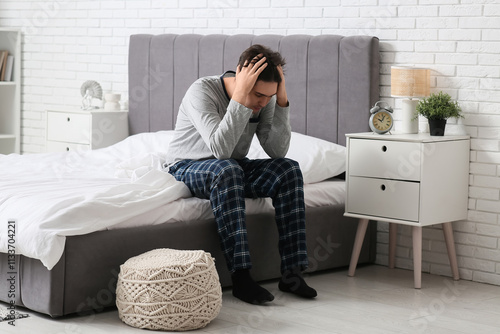 Depressed young man sitting...