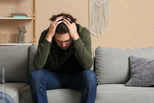 Depressed young man sitting...