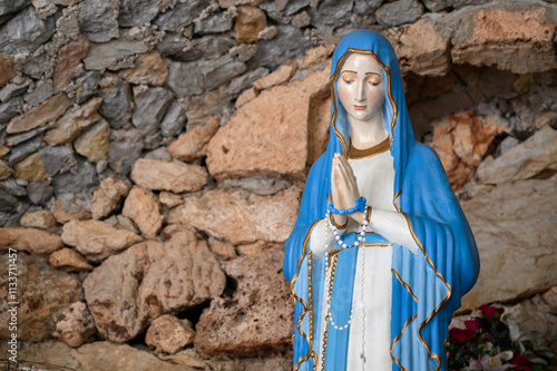 Our Lady of Lourdes – a statue in a grotto near the Church of the Sacred Heart of Jesus in Studenci, Bosnia and Herzegovina. photo