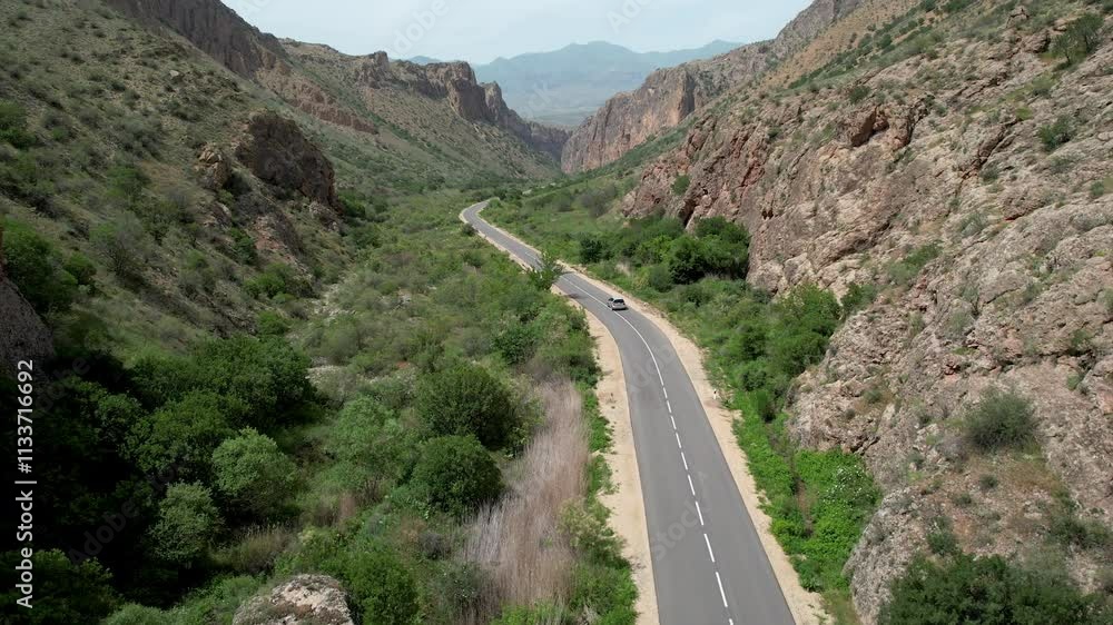 Drone follows a car driving on the road in Noravank Gorge on sunny spring day. Armenia. Drone follows a car driving on the road in Noravank Gorge on sunny spring day. Armenia.