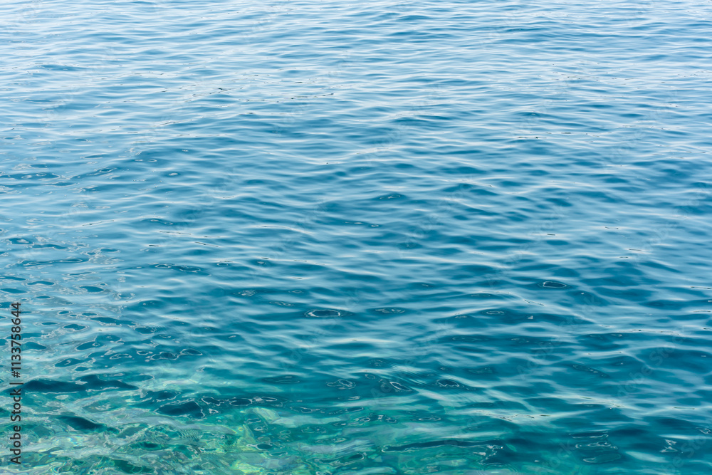 Calm turquoise water surface with soft ripples and natural sunlight reflections on a clear day. Concept of tranquility, nature, and serene aquatic textures. Calm turquoise water surface with soft ripples and natural sunlight reflections on a clear day. Concept of tranquility, nature, and serene aquatic textures.