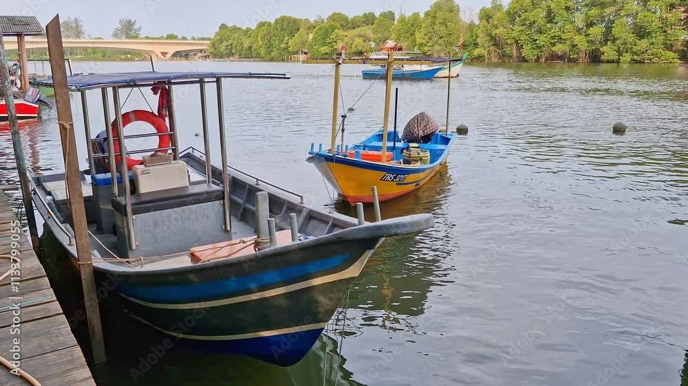 Static shot of simple traditional boats made from wooden and fiberglass material docked on a calm river mouth. These fishing boats were operated by locals. Static shot of simple traditional boats made from wooden and fiberglass material docked on a calm river mouth. These fishing boats were operated by locals.