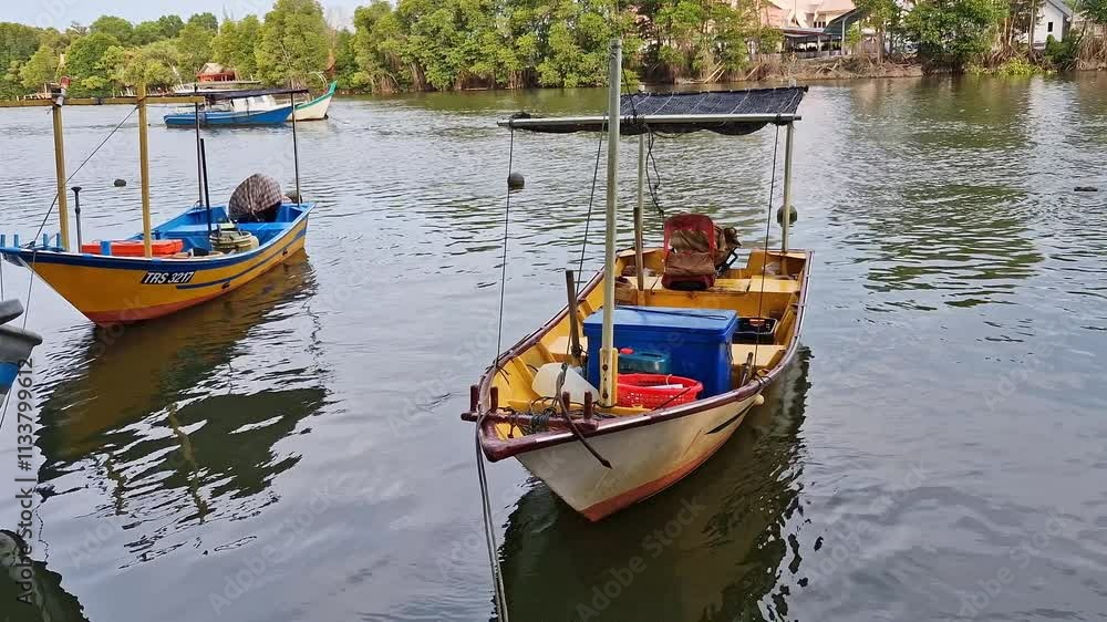 Static shot of simple traditional boats made from wooden and fiberglass material docked on a calm river mouth. These fishing boats were operated by locals. Static shot of simple traditional boats made from wooden and fiberglass material docked on a calm river mouth. These fishing boats were operated by locals.