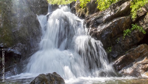 Crystal Clear Waterfall Cascading Over Jagged Rocks in Hidden Forest Valley