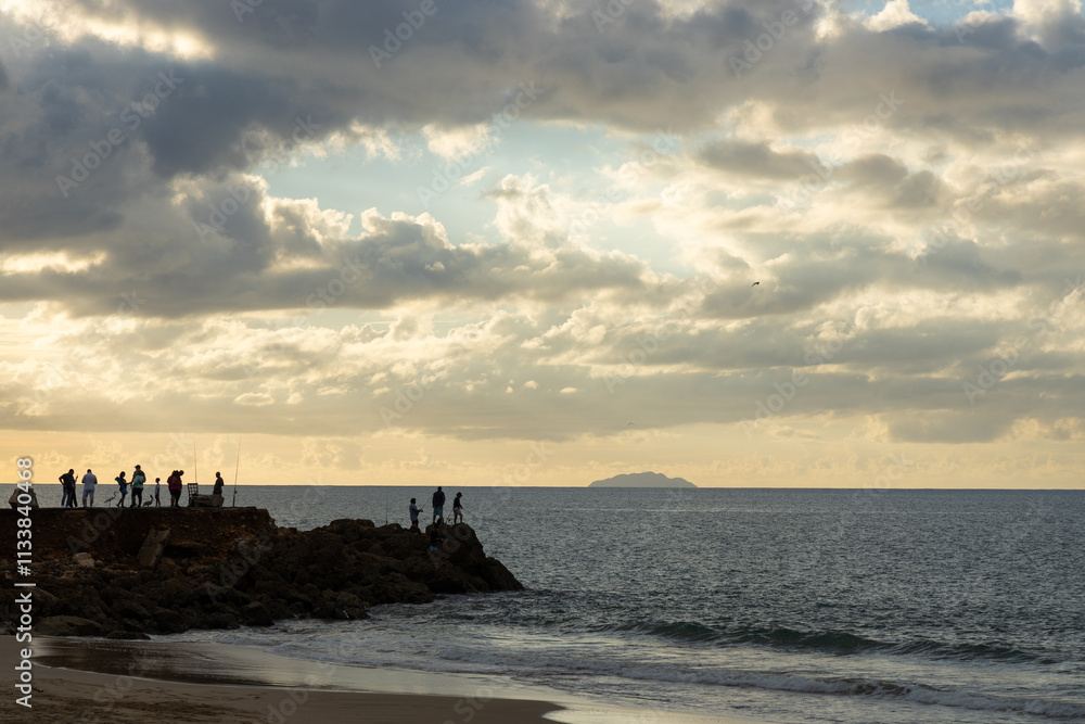 Fishermen fishing from the shore during sunset in Aguadilla, Puerto Rico Fishermen fishing from the shore during sunset in Aguadilla, Puerto Rico