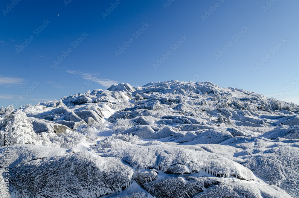 Fototapeta premium Stunning winter landscape of Mount Monadnock in New Hampshire covered in snow and frost under a clear blue sky