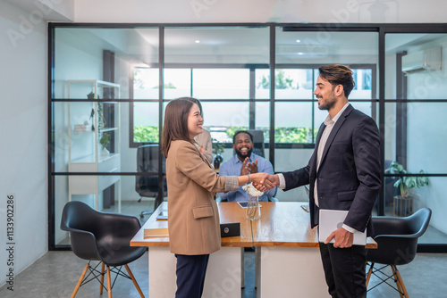 multiracial business partnership meeting in the office room, an asian businesswoman smile shaking hand with caucasian businessman for the future business cooperation