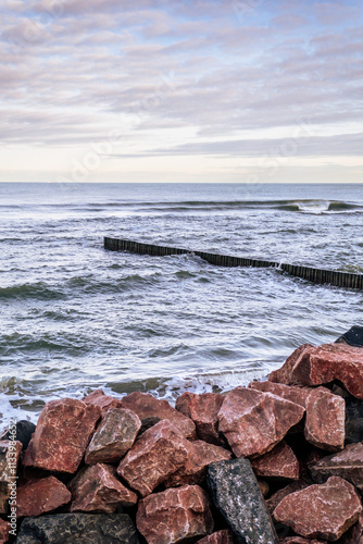 Wallpaper Mural Calm Ocean Waves Gently Lap Against a Rocky Jetty at Dawn Near a Serene Coastline Torontodigital.ca