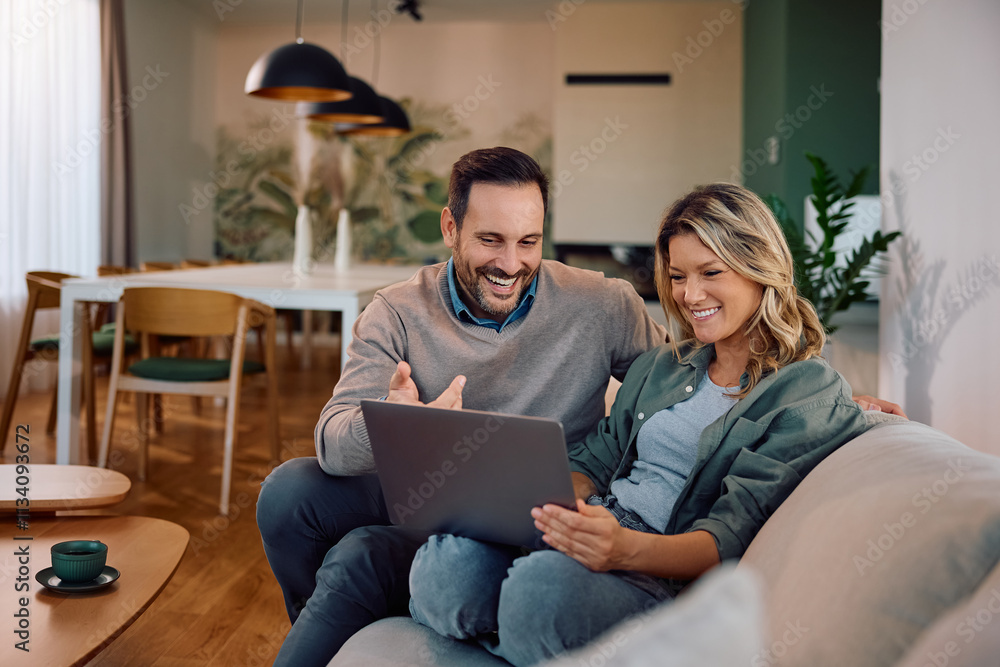 Happy couple surfing the net on laptop while relaxing in their living room. Happy couple surfing the net on laptop while relaxing in their living room.