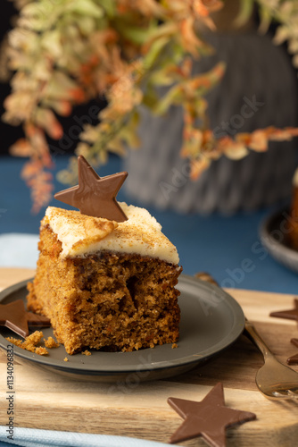 Piece of cake iced with cream cheese icing and topped with a chocolate star