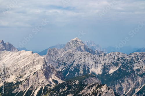 Panoramic view of rugged mountain ridge Mangart in majestic Julian Alps seen from top of summit Spik. Adventure and freedom in Triglav National Park, Slovenia, Slovenian Alps. Jagged alpine terrain photo