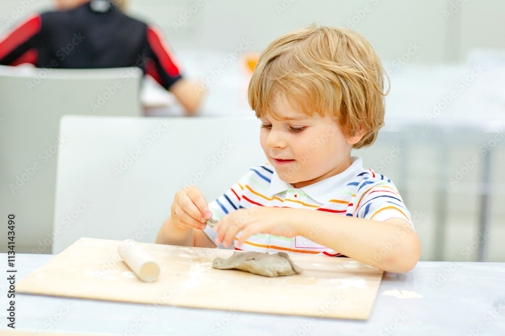 Little blond boy modeling with clay at master class art in a museum, indoors. Creative leisure for kids in kindergarden and at home, indoors. Little blond boy modeling with clay at master class art in a museum, indoors. Creative leisure for kids in kindergarden and at home, indoors.