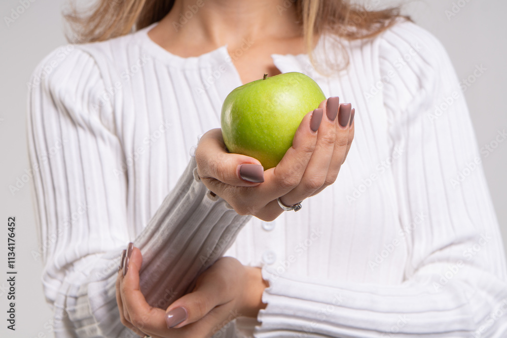 Green apple in womans hands close-up Green apple in womans hands close-up