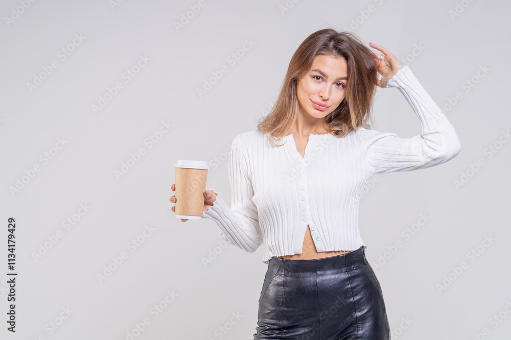 Attractive brunette young woman holding a cofee cup and standing on a white background. Copy space, close-up portrait Attractive brunette young woman holding a cofee cup and standing on a white background. Copy space, close-up portrait