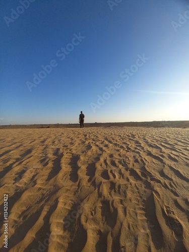 person walking on the sand dunes